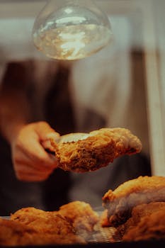 Delicious fried chicken served hot and fresh under a warm light display.
