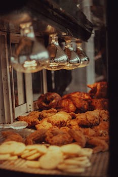 A tempting array of golden fried chicken pieces displayed under warm lights at a local eatery in Mexicali.