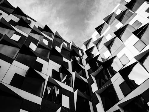 Free Grayscale Photo of a Building under a Cloudy Sky Stock Photo