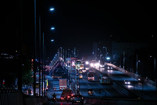 Dramatic night view of a busy highway bridge with moving traffic in India.