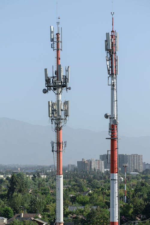 Two Cell Towers near an Urban Skylline 