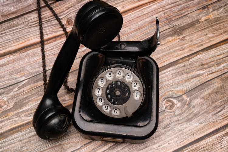 Black Rotary Phone On Brown Wooden Table