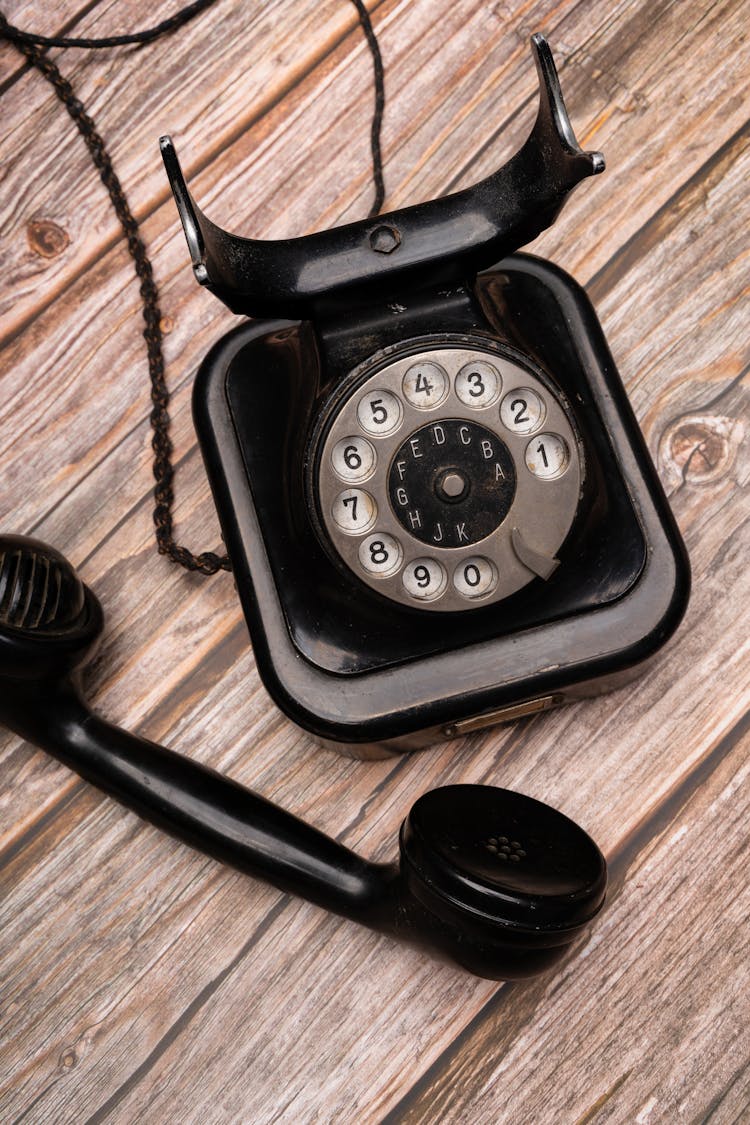 Black Rotary Phone On Brown Wooden Table