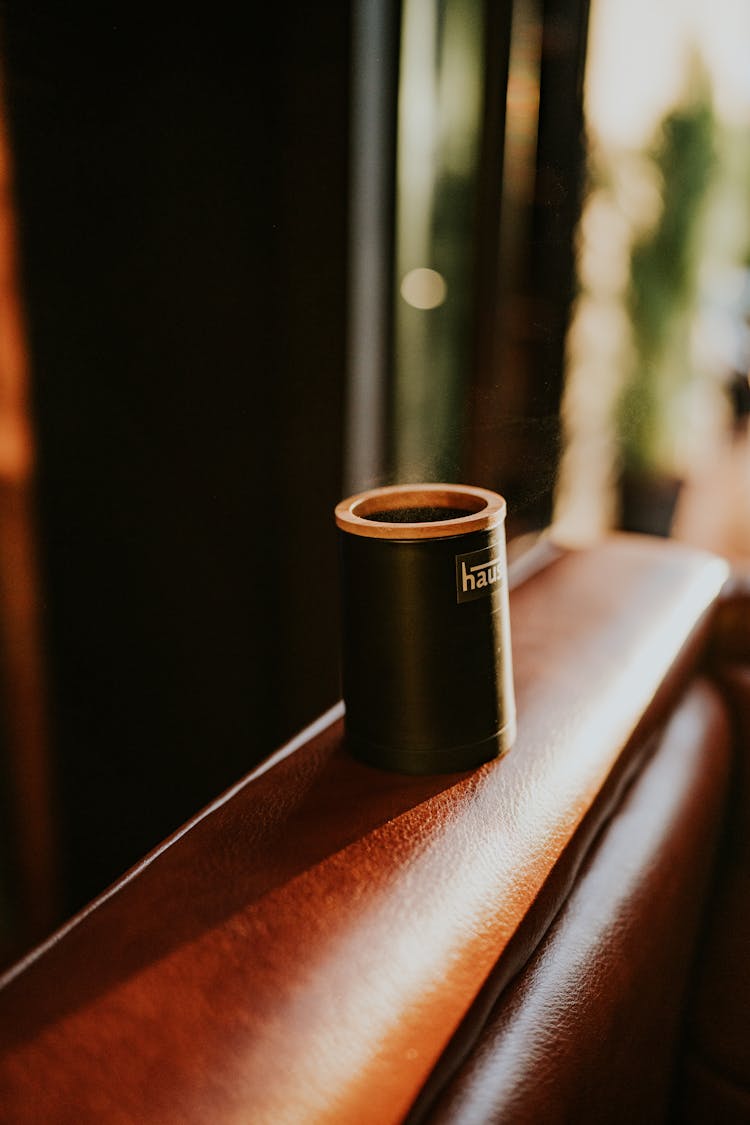 Coffee Cup On A Sofa Armrest 