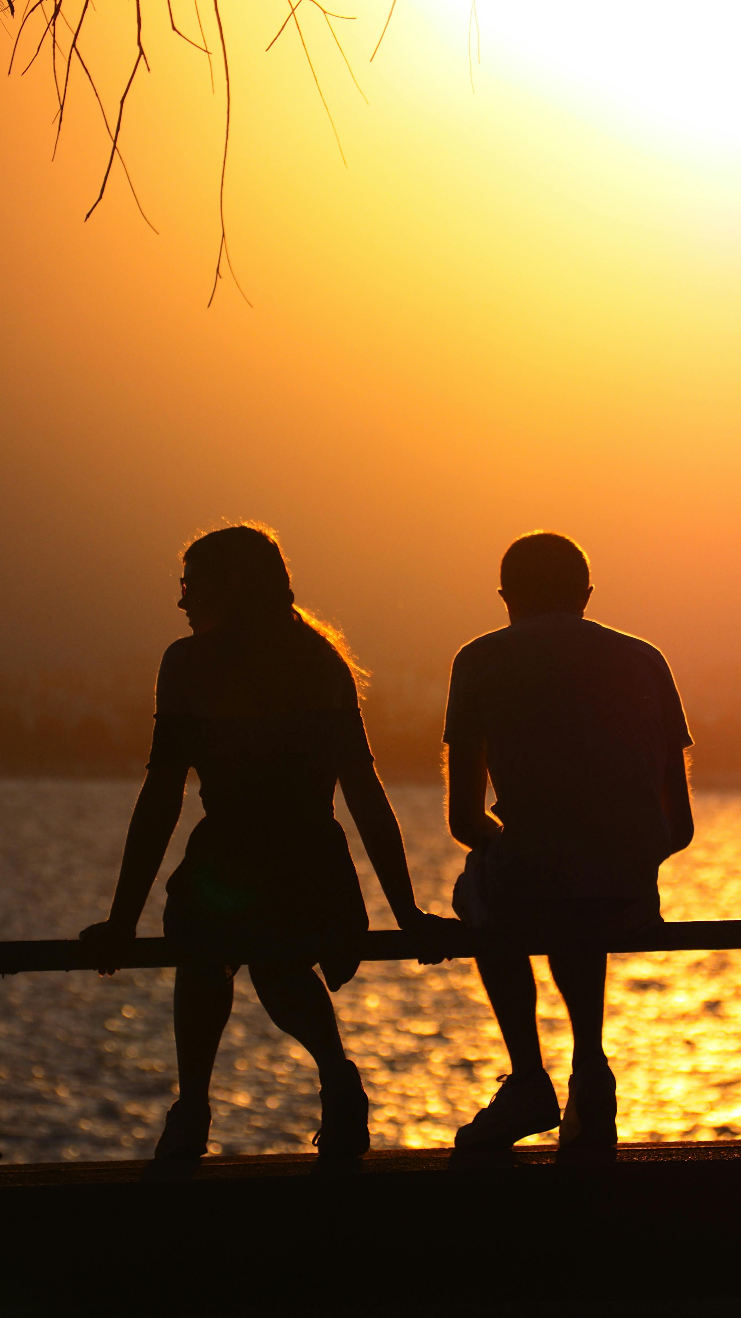 Silhouette of Man and Woman Sitting on the Railings · Free Stock Photo, image size:2592x4608