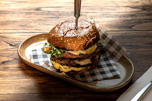 Cheeseburger with Knife, on Wooden Table