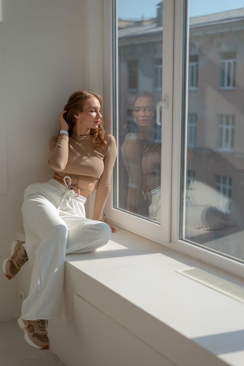 Una Mujer Sentada Cerca De La Ventana · Foto de stock gratuita