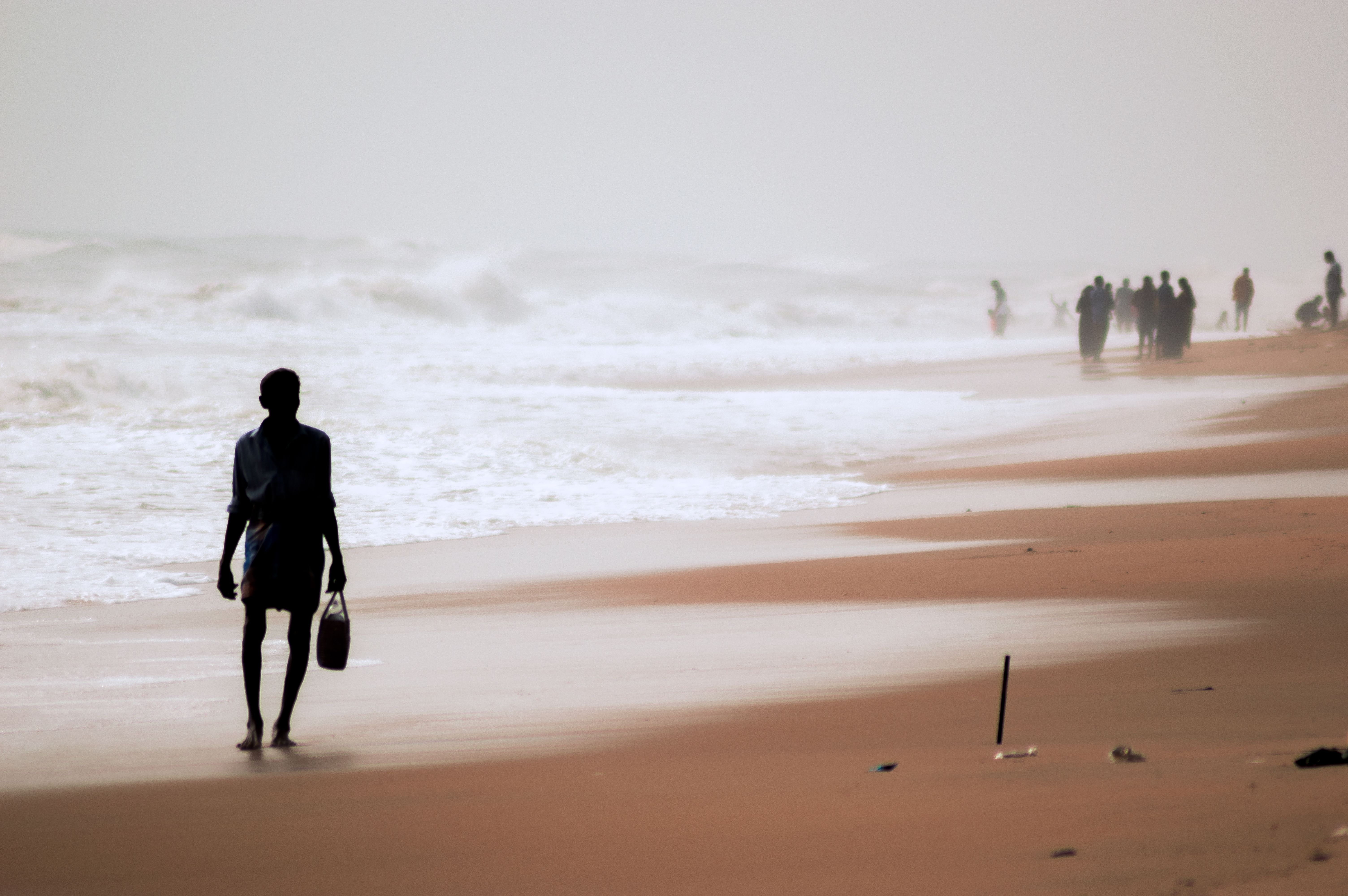 Silhouette of a person standing barefoot on sand, Benin
