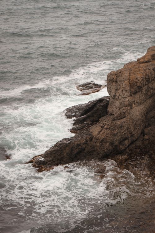 Free A dramatic view of a rocky coastline with waves crashing, capturing the serene power of nature. Stock Photo