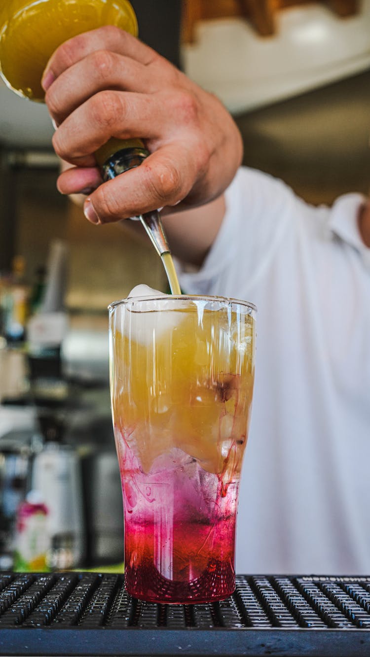 Person Poring Juice In A Cocktail Drink