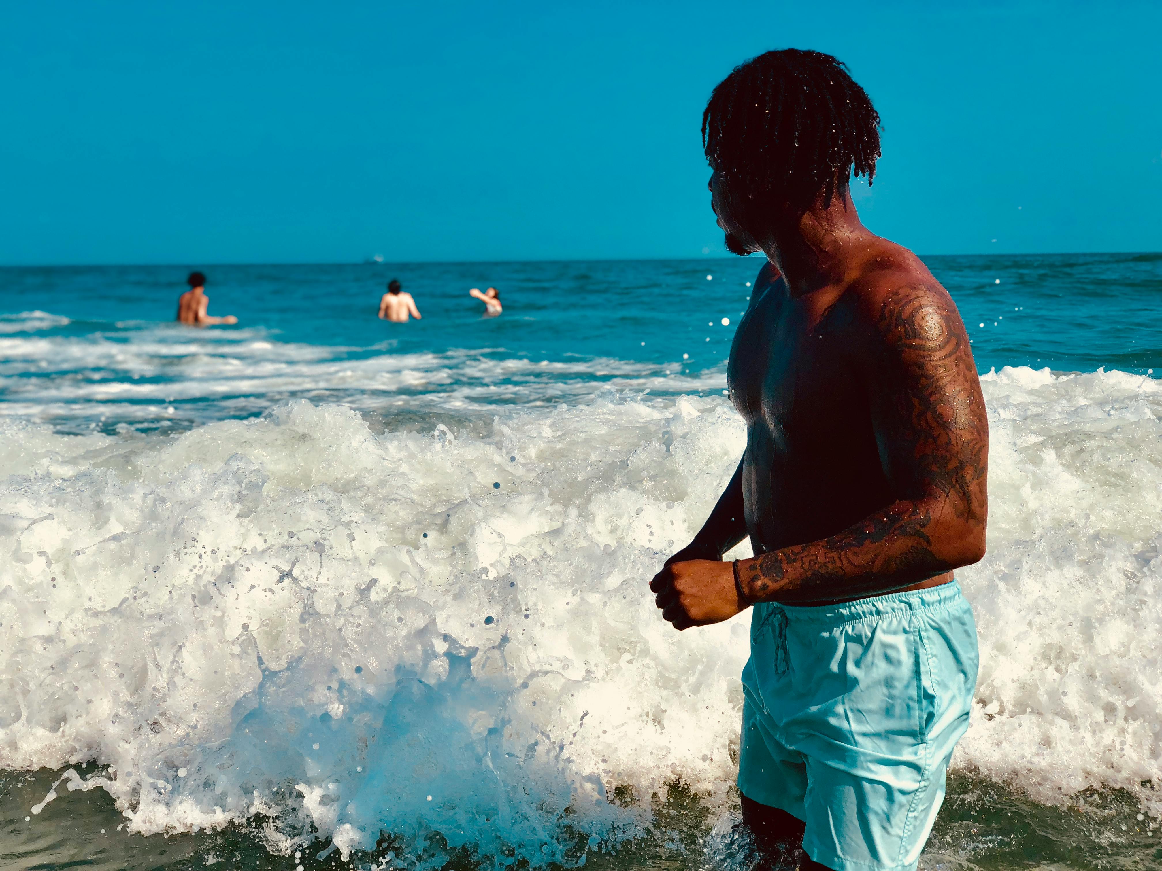 Homme noir appliquant de la crème solaire pour protéger sa peau des rayons UV