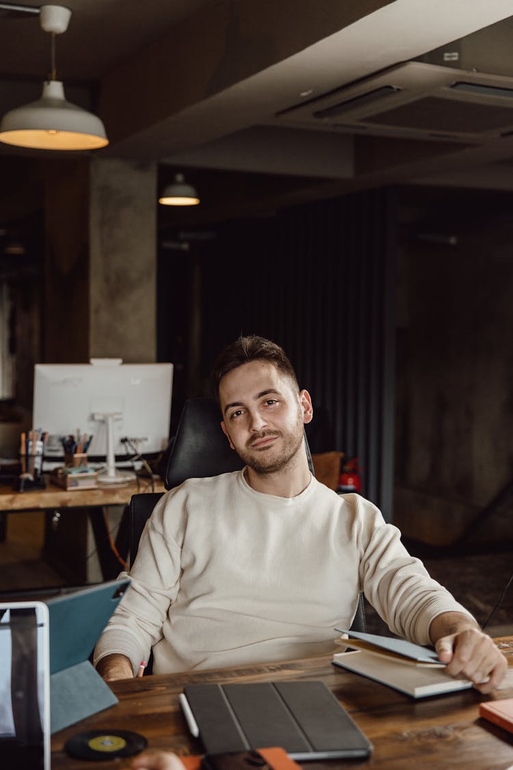 A Man Wearing Sweater Sitting At The Table