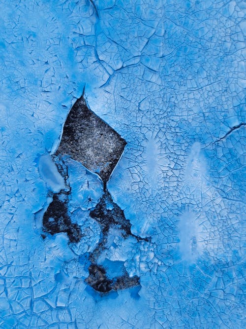 A Close-Up Shot of a Blue Paint Peeling Off a Wall