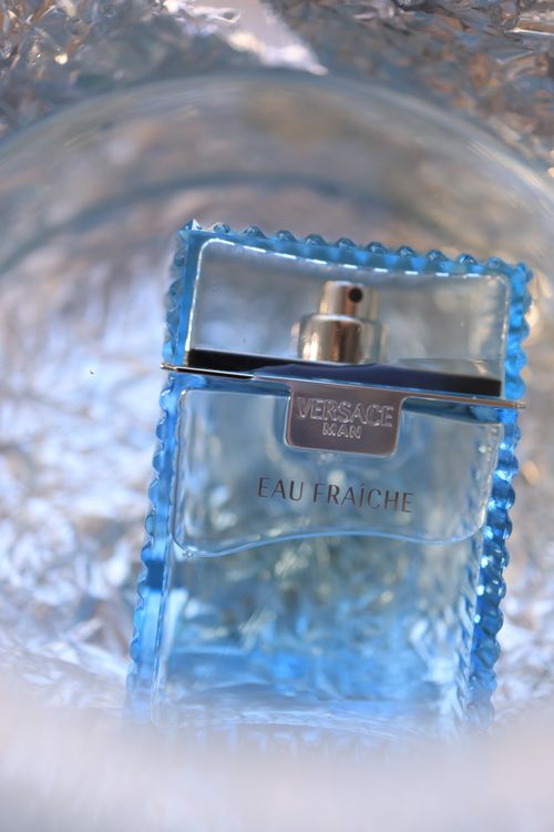 Free Close-up of Versace Eau Fraiche bottle with stylish design and shimmering background. Stock Photo