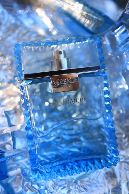 Free Luxurious blue glass perfume bottle elegant on reflective icy surface. Stock Photo