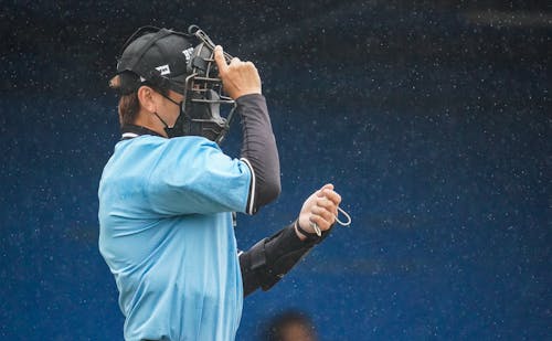 A Man Wearing a Catcher Helmet