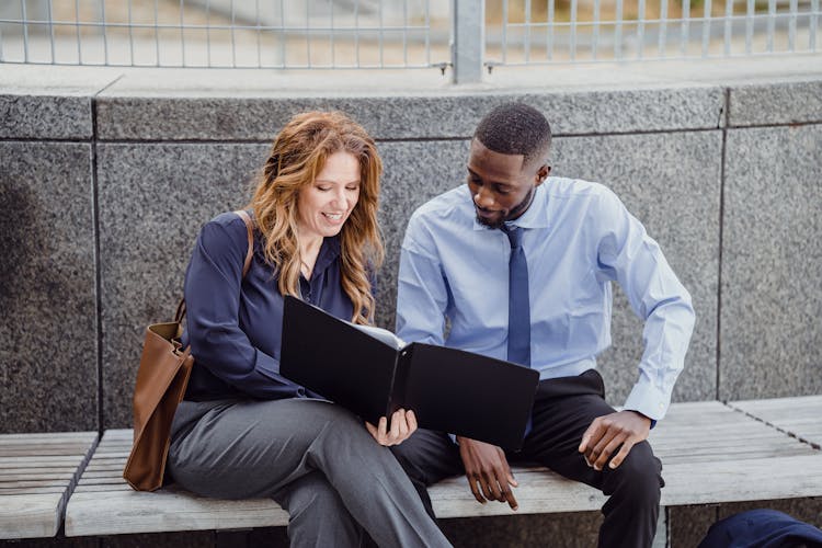 Businesspeople Discussing Document Outdoors