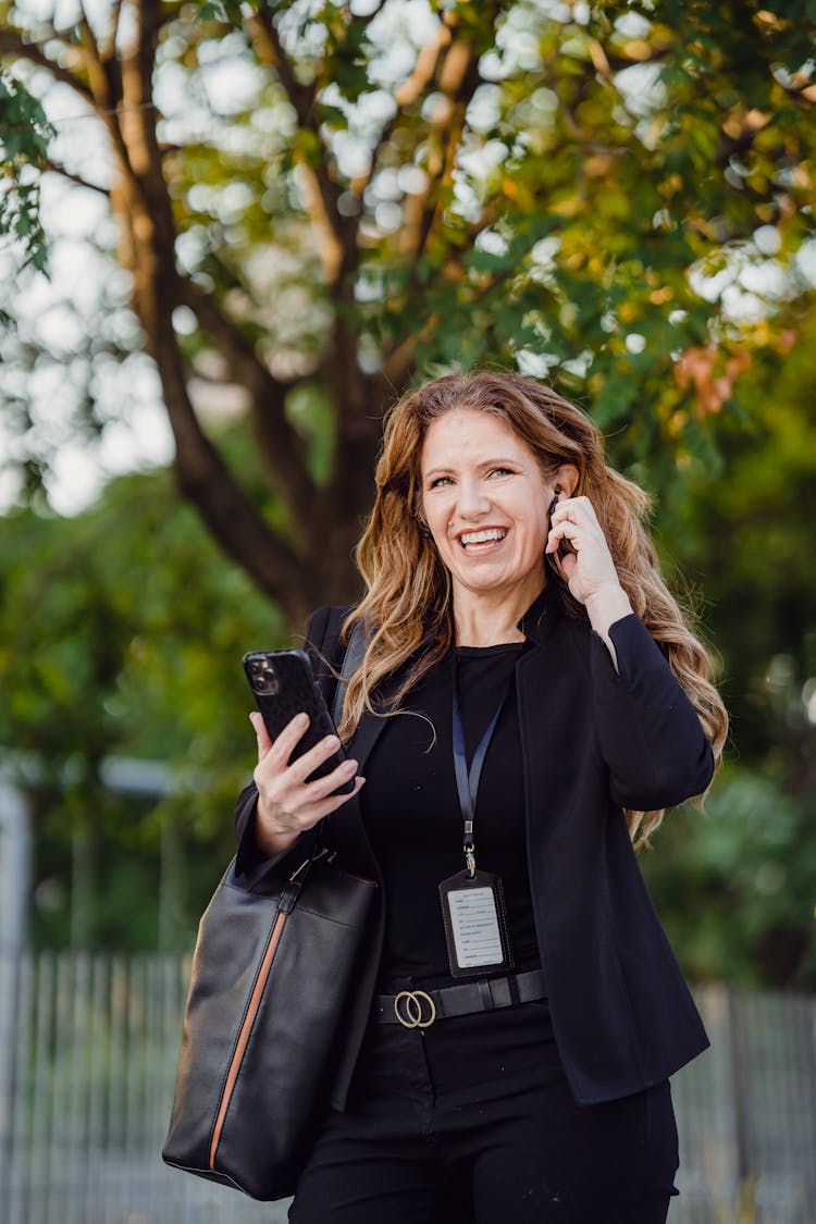 Smiling Businesswoman Talking On Mobile In Park