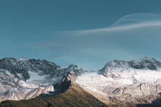 Beautiful snow-covered mountains with a clear blue sky, showcasing a serene winter landscape.