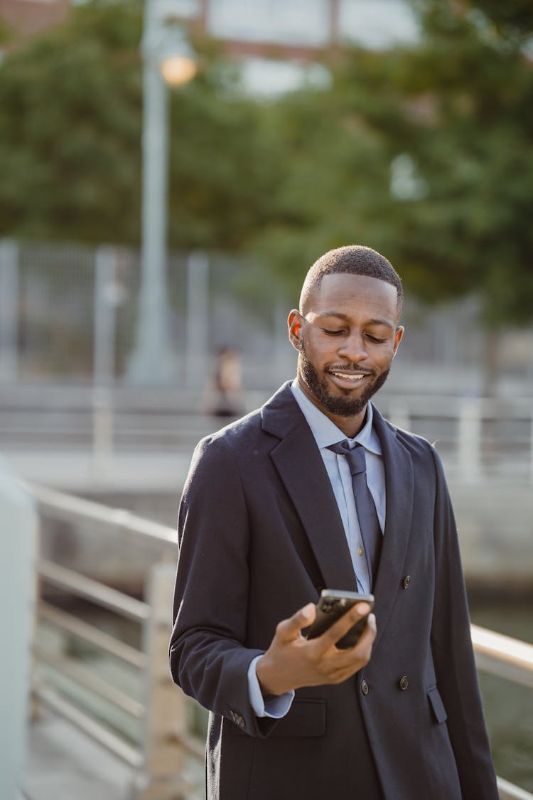 Smiling Businessman Using Cellphone Outdoors