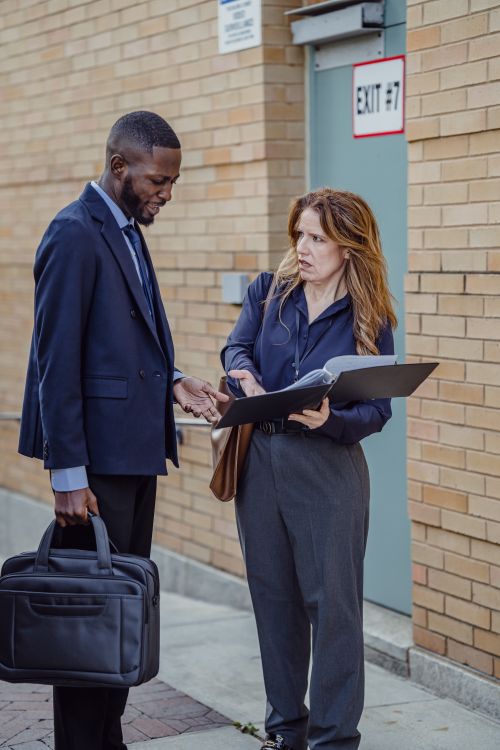 Free Two business individuals engaged in a discussion outdoors near an exit. Stock Photo