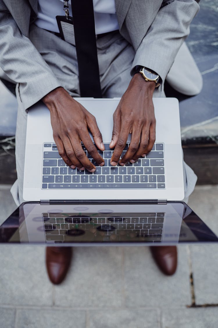 A Man Typing On A Laptop