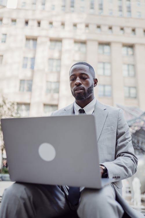 A Man with a Laptop in a City