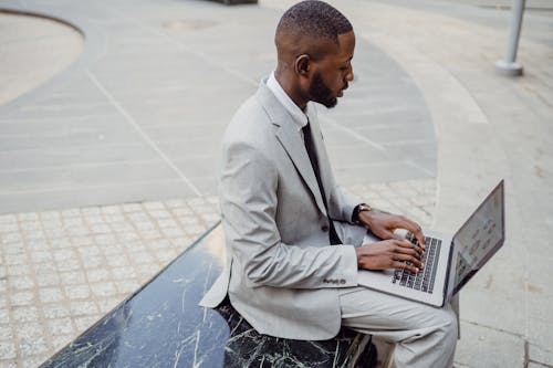 afrikalı amerikalı adam, dizüstü bilgisayar kullanarak, kentsel içeren Ücretsiz stok fotoğraf