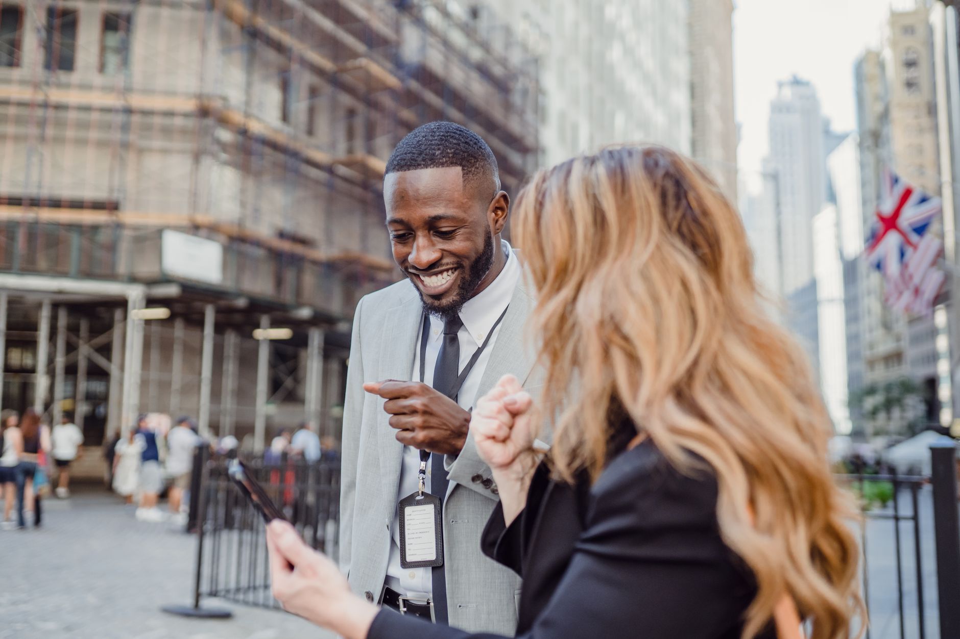 Two business professionals engage in lively conversation on an urban street, sharing insights.