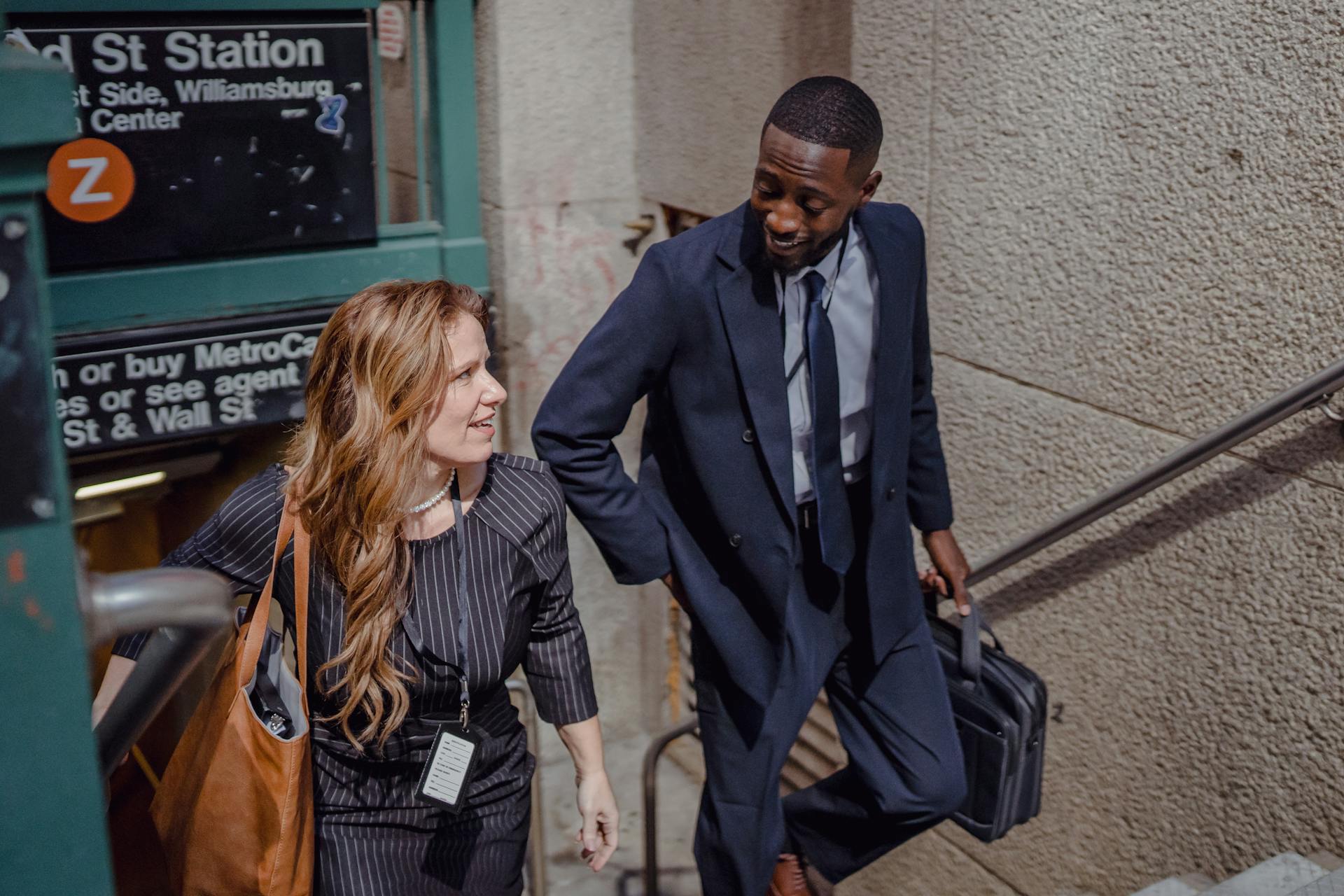 Photo of Smiling Two People Walking out of the Subway Station