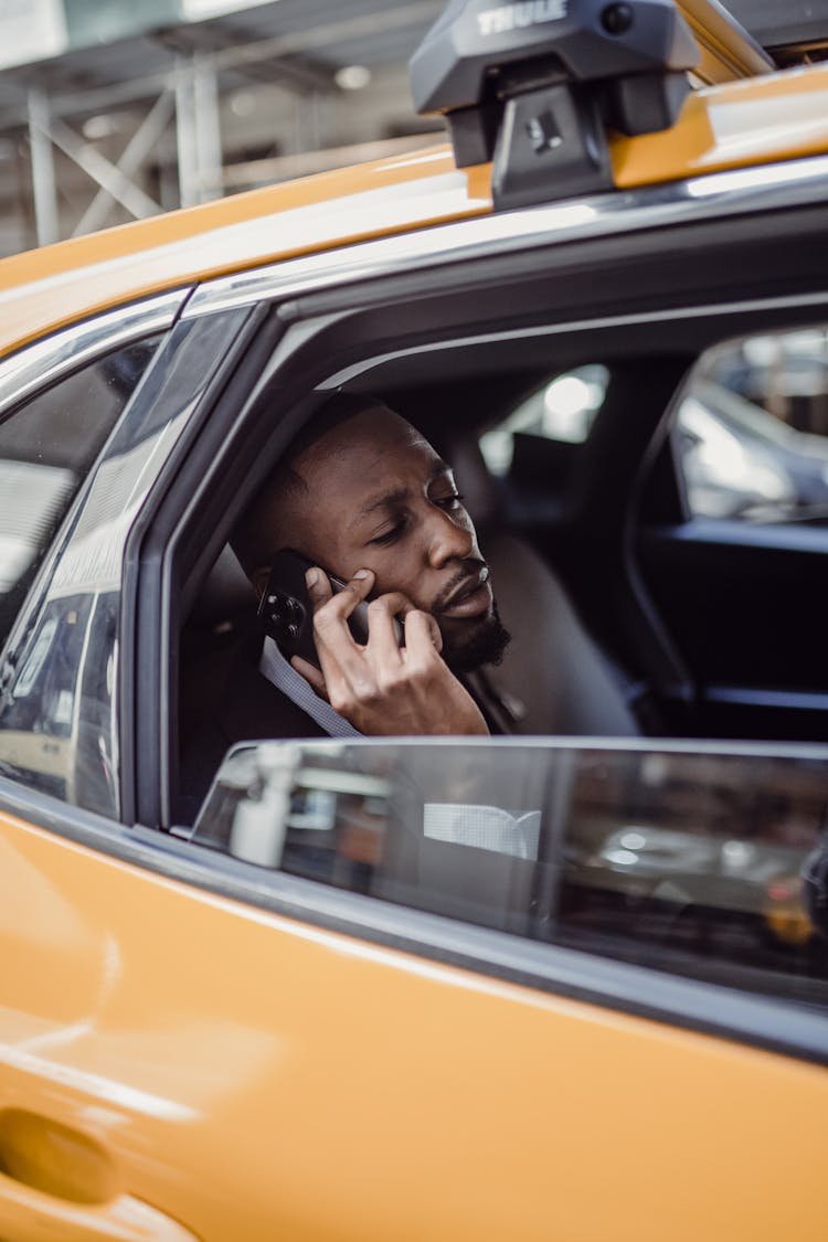 Man Sitting In A Taxi And Talking On The Phone 