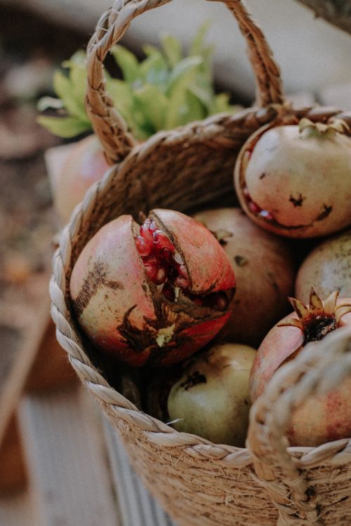 Free A close-up of ripe pomegranates in a woven basket, showcasing freshness and natural beauty. Stock Photo