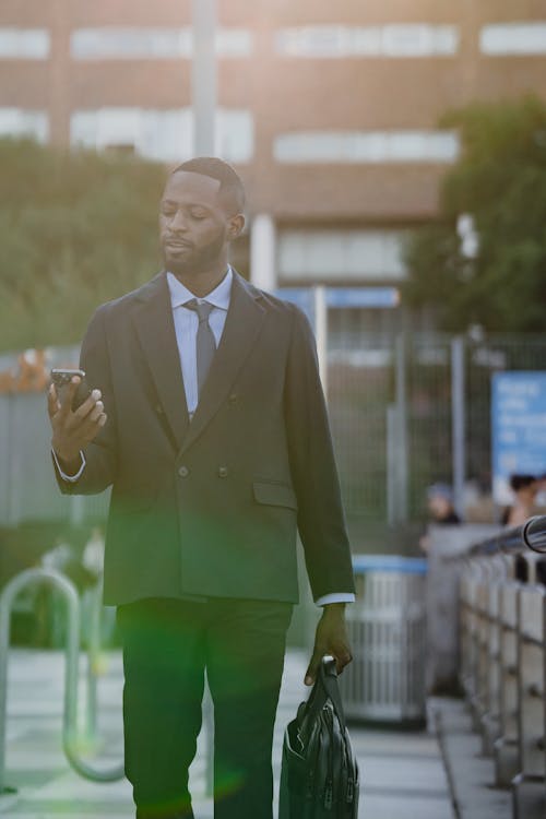 Man in Suit Looking at Cellphone