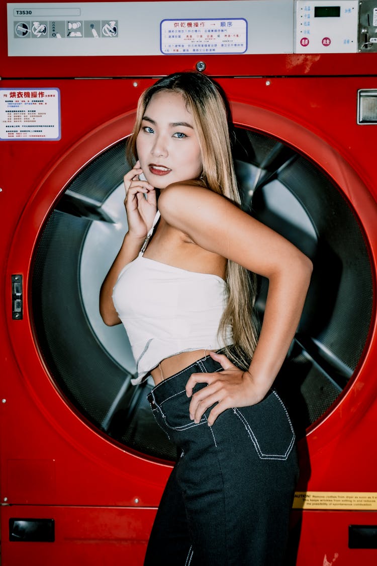 Woman In Pants And Top Against Washing Machine