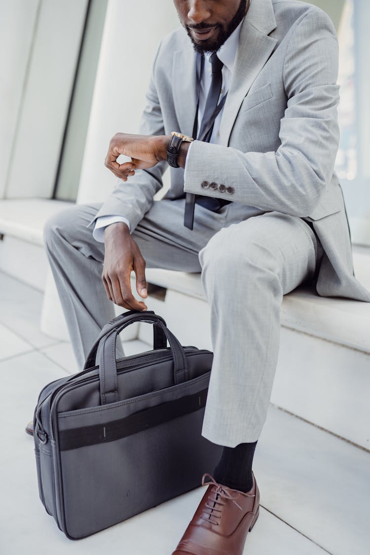 Man With Bag Looking At Watch