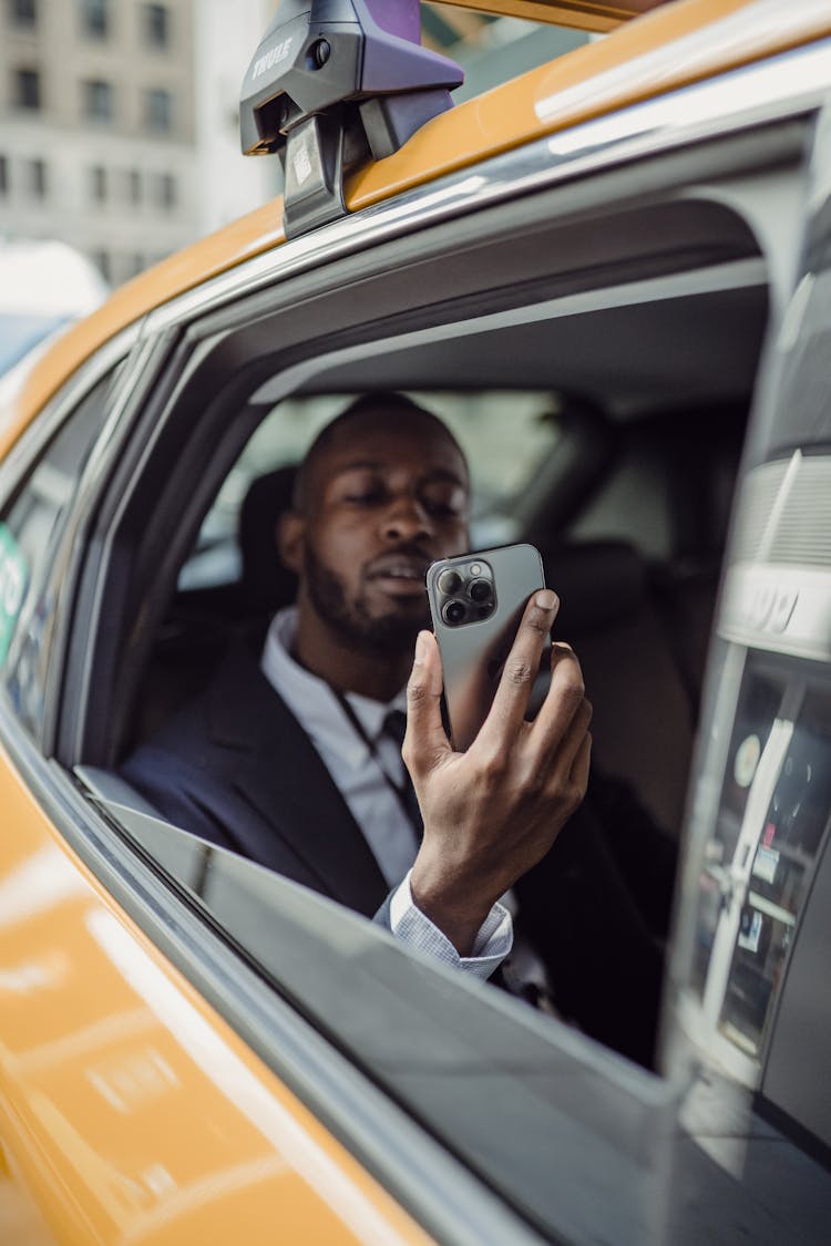 Man Looking At Cellphone In Taxi