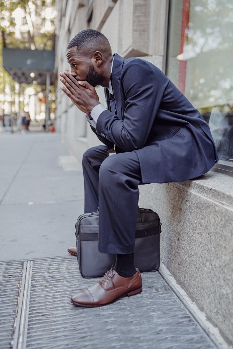 Man Sitting On Wall And Thinking