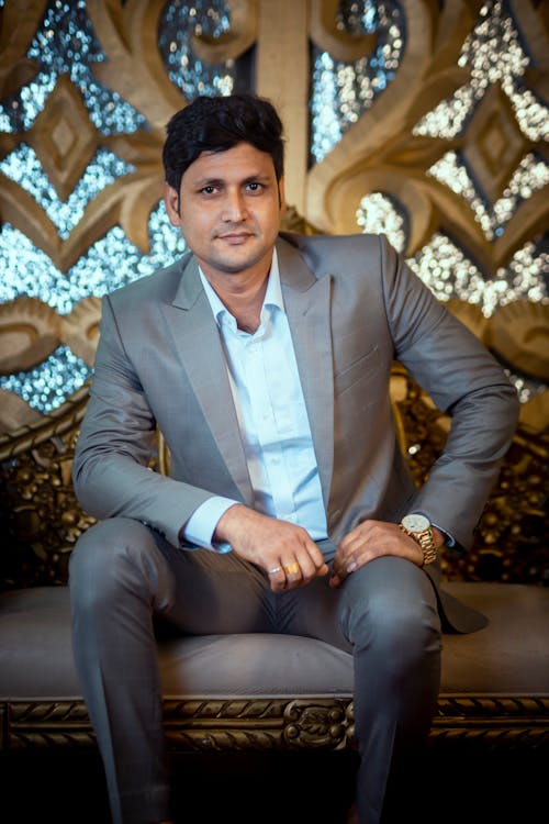 Man in Gray Suit Sitting on Brown Sofa Chair