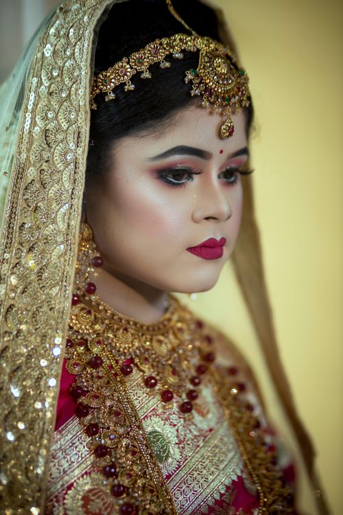 Free A South Asian bride elegantly dressed in traditional bridal attire with intricate jewelry and makeup. Stock Photo