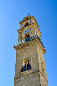 Stone clock tower in Jerez de la Frontera under clear blue sky, Andalucía, Spain.