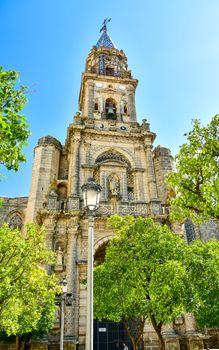 Vertical shot of the detailed facade of a historic church in Jerez de la Frontera, Spain, under a clear blue sky.