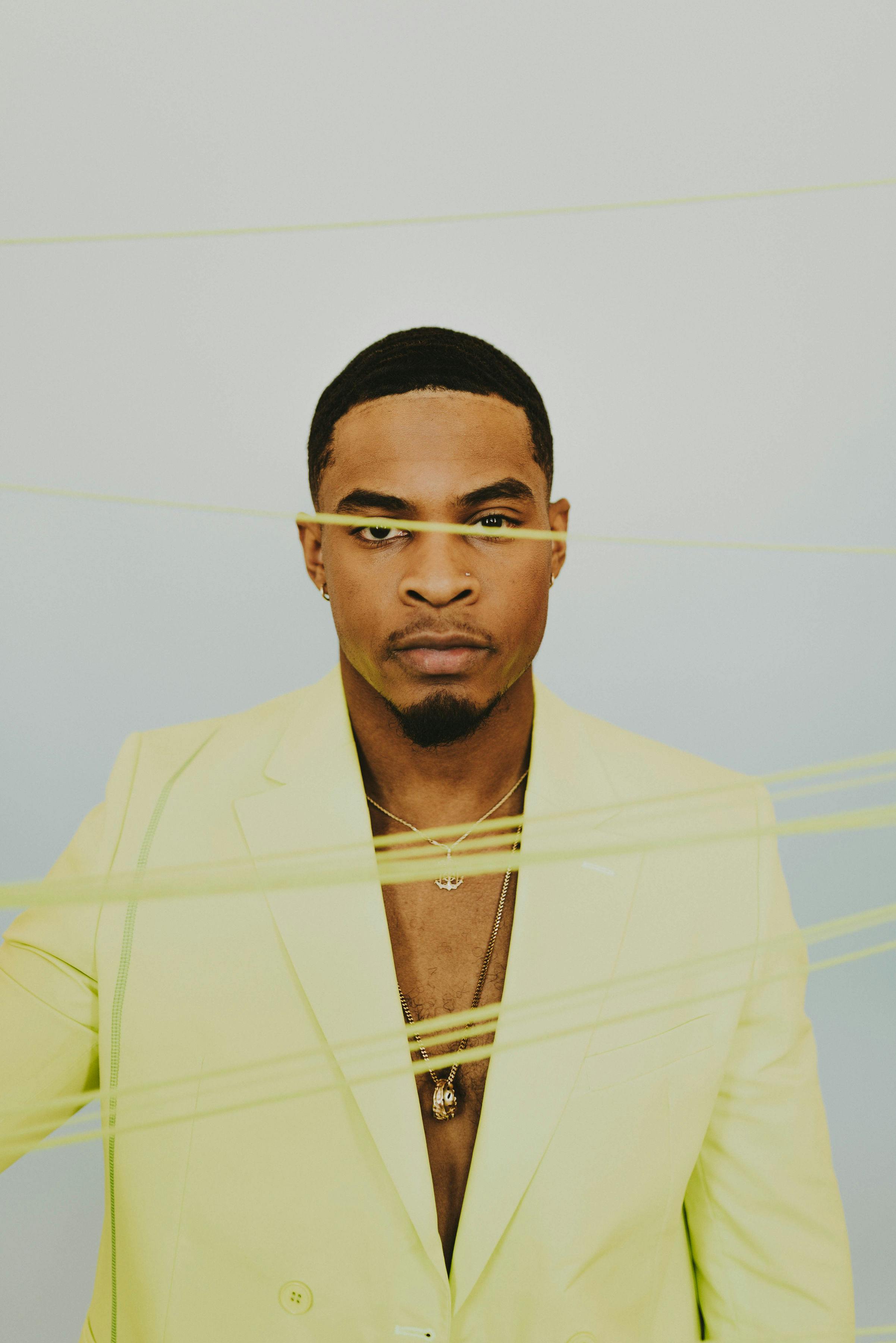 A striking portrait capturing a man in vibrant yellow attire with expressive facial features.