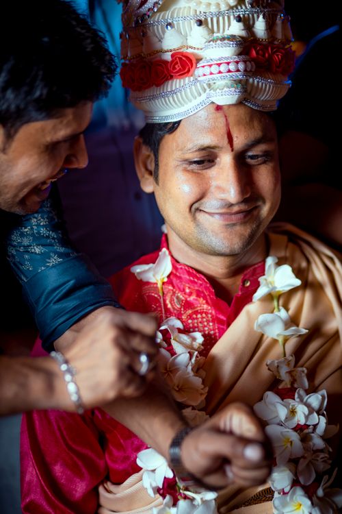 Free Smiling groom in traditional Indian attire adorned with flowers during a joyous wedding ceremony. Stock Photo