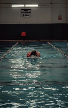Swimmer in action in an indoor pool in San Luis Potosí, México, showcasing athletic training.