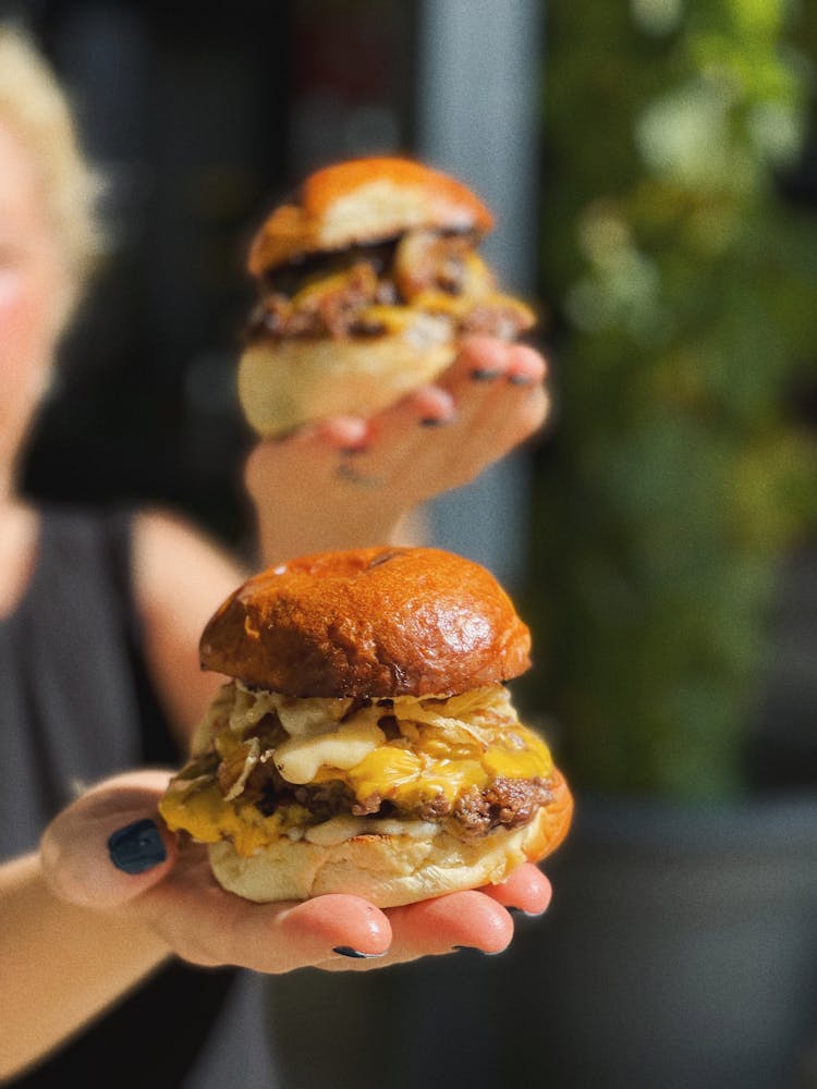 Person With Hamburgers On Hands