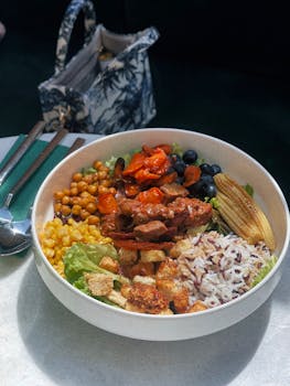 Delicious and nutritious grain bowl with assorted vegetables, grilled meat, and fresh ingredients.