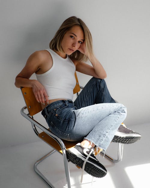 Woman Wearing Jeans Sitting on a Chair 