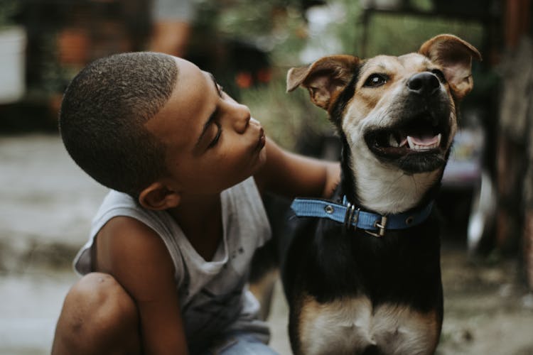 Boy Giving A Kiss To His Dog 