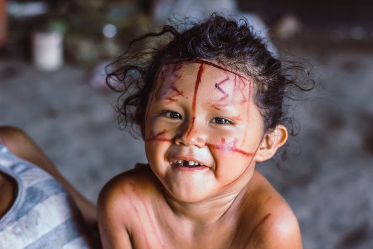 A Cute Kid With Brown Face Paint