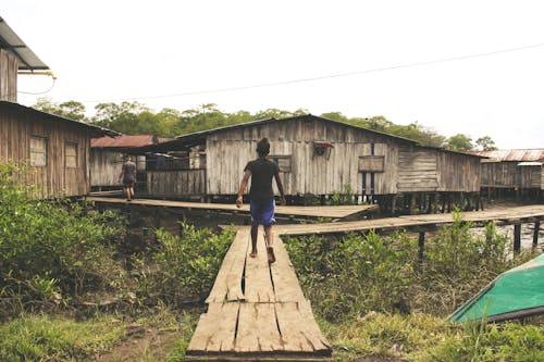 Back View of a Man Walking on Wooden Dock 